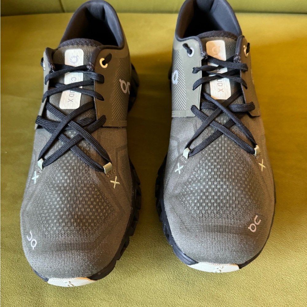 On cloud X olive colored running shoes.